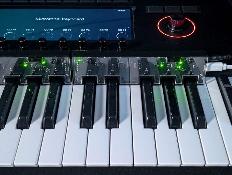 Microtonal keyboard under development. A sensor attached to the keys detects finger movement, enabling fine pitch changes for each key. The control technology for the sensors utilizes know-how learned from robot construction.