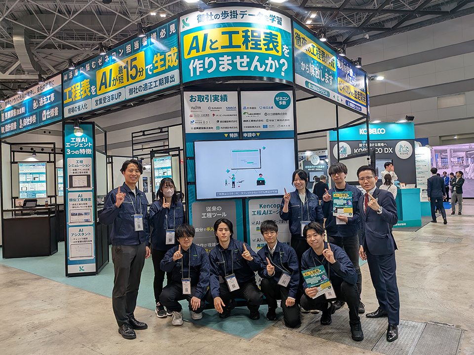 Team group photo at the Construction DX Exhibition booth